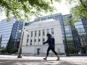 Une femme passe devant le siège social de la Banque du Canada, le mercredi 1er juin 2022 à Ottawa.