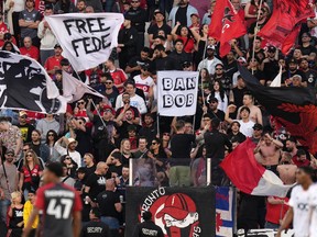 Les fans du Toronto FC agitent des banderoles.