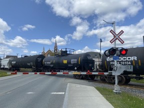 Une voiture de train DOT111, centre, transporte des matières dangereuses, aussi appelées 