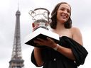 Iga Swiatek de Pologne célèbre avec le Trophée Suzanne Lenglen sur le pont de Bir-Hakeim après avoir remporté l'Open de France.