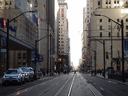 Des piétons traversent l'intersection de Bay Street et de Wellington Street West dans le quartier financier de Toronto en mars 2021. 