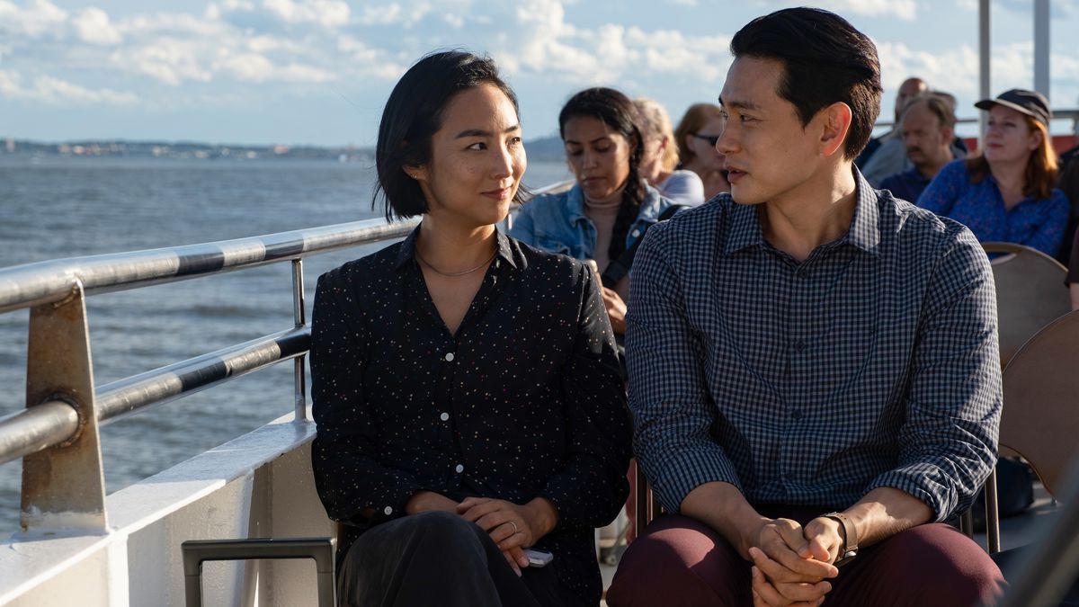 Nora et Hae Sung sont assis sur un ferry en direction de la Statue de la Liberté.