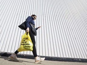 Une personne quitte un supermarché de Toronto avec des produits d'épicerie le mercredi 5 octobre 2022.