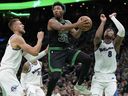 DOSSIER – Le garde des Boston Celtics Marcus Smart, au centre, cherche à dépasser le centre des Washington Wizards Kristaps Porzingis, à gauche, et l'attaquant Rui Hachimura, à droite, pendant la première moitié d'un match de basket NBA le 30 octobre 2022 à Boston.  Une personne au courant de l'accord a déclaré que les sorciers avaient accepté d'échanger Porzingis avec les Celtics.  La personne a parlé à l'Associated Press sous couvert d'anonymat car l'accord n'avait pas été annoncé.  L'échange s'accompagne de l'acceptation par Porzingis de son option de joueur pour la saison prochaine.  ESPN rapporte que l'accord inclut également les Memphis Grizzlies qui acquièrent Smart de Boston en échange de choix de première ronde en 2023 et 2024.