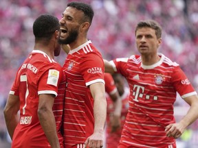 DOSSIER – Serge Gnabry du Bayern, à gauche, célèbre en plus de son coéquipier Noussair Mazraoui du Bayern et Thomas Mueller du Bayern après avoir marqué le premier but de son équipe lors du match de football de Bundesliga allemande entre le FC Bayern Munich et le Hertha BSC Berlin au stade Allianz Arena de Munich, en Allemagne, le 30 avril 2023. Le Bayern Munich et Qatar Airways ont annoncé mercredi 28 juin 2023 qu'ils mettaient fin à un accord de sponsoring qui a provoqué des tensions entre le champion de football allemand et ses fans.