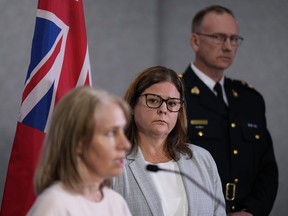 La première ministre du Manitoba, Heather Stefanson, arrière-centre, et le surintendant de la GRC.  Rob Lasson, au fond à droite, écoute Lanette Siragusa, PDG de Shared Health, parler de l'accident d'autobus de Carberry lors d'une conférence de presse au quartier général de la GRC, à Winnipeg, le lundi 19 juin 2023. Stefanson dit que la province fera appel à des experts si nécessaire dans le cadre d'un examen pour assurer la sécurité à une intersection où 15 personnes âgées ont été tuées dans un accident.