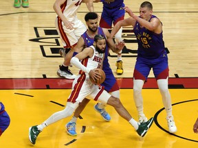 Caleb Martin # 16 des Miami Heat conduit au panier contre Jamal Murray # 27 et Nikola Jokic # 15 des Denver Nuggets lors de la première mi-temps du troisième match de la finale NBA 2023 au Kaseya Center le 07 juin 2023 à Miami.