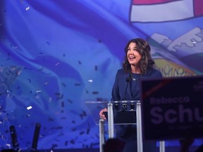 Danielle Smith sourit debout derrière un podium.