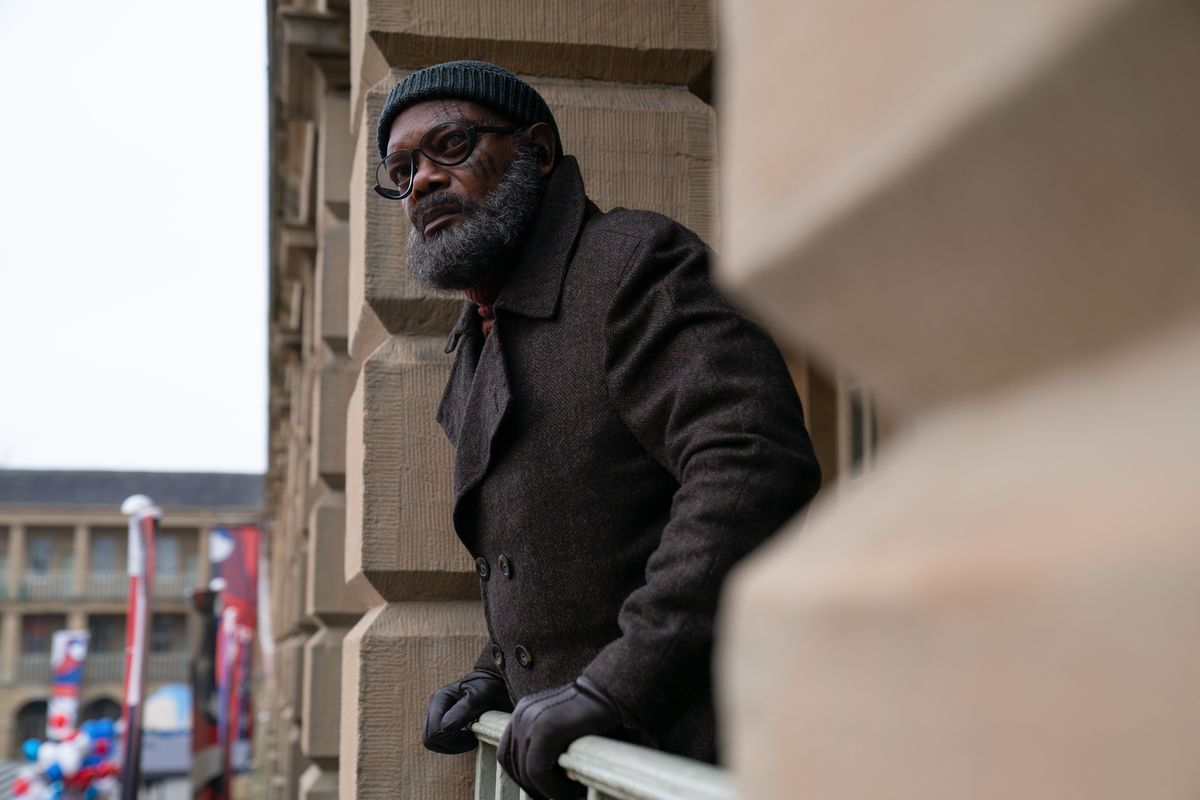 Nick Fury (Samuel L. Jackson) se penche sur une balustrade en regardant quelque chose