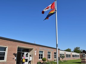 Le drapeau de la fierté flotte devant une école.