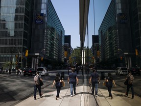 Des piétons marchent près d'un immeuble de la Banque Royale du Canada dans le quartier financier de Toronto.