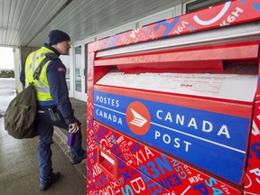 Une boîte aux lettres et un employé de Postes Canada