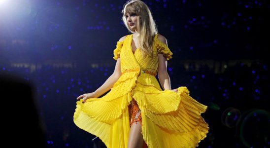 Taylor Swift showing off her yellow duster on the Eras Tour.