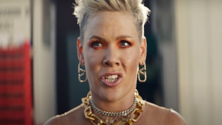 Pink with earrings and necklaces in music video for Never Gonna Not Dance Again