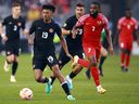 Charles Brym du Canada est poursuivi par Johan Rotsen de Guadeloupe lors de leur match de la Gold Cup.