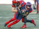 Le receveur des Alouettes de Montréal Quan Bray est plaqué par Nate Holley des Stampeders de Calgary lors d'un match à Montréal le 5 octobre 2019. 