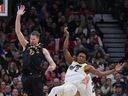 Le centre des Raptors de Toronto Jakob Poeltl (19 ans) se bat pour le ballon avec le garde de l'Utah Jazz Collin Sexton (2) au cours du deuxième trimestre à la Scotiabank Arena.