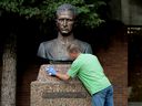 Un bénévole frotte la peinture en aérosol sur la statue de Roman Shukhevych au Complexe de l'unité de la jeunesse ukrainienne, 9615 153 Ave., à Edmonton le mardi 10 août 2021. 