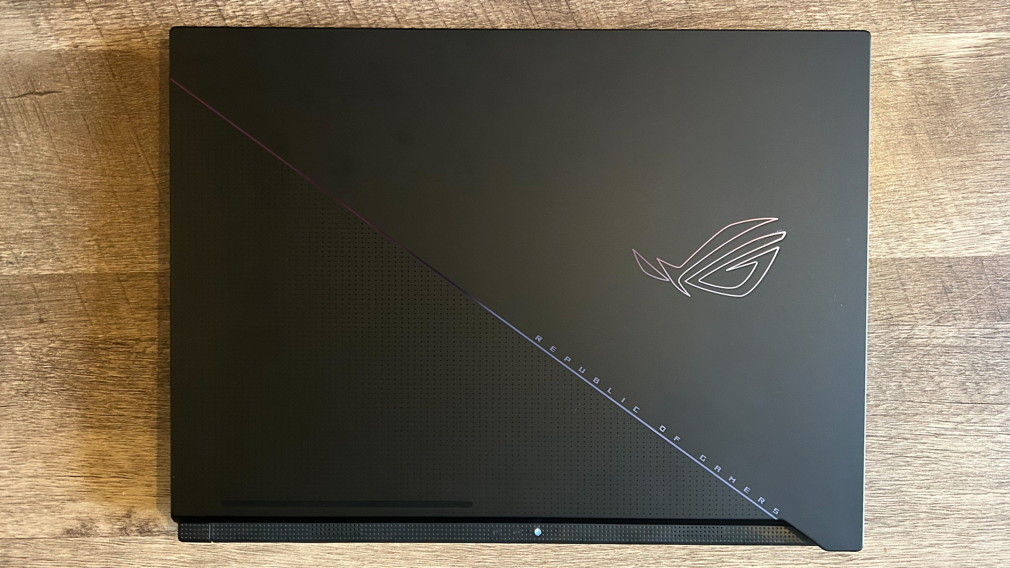 Asus ROG Zephyrus Duo 16 avec couvercle fermé sur une table en bois