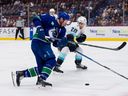 Le défenseur du Kraken de Seattle, Carson Soucy, vérifie l'attaquant des Canucks de Vancouver, JT Miller, lors d'un match du 4 avril au Rogers Arena.