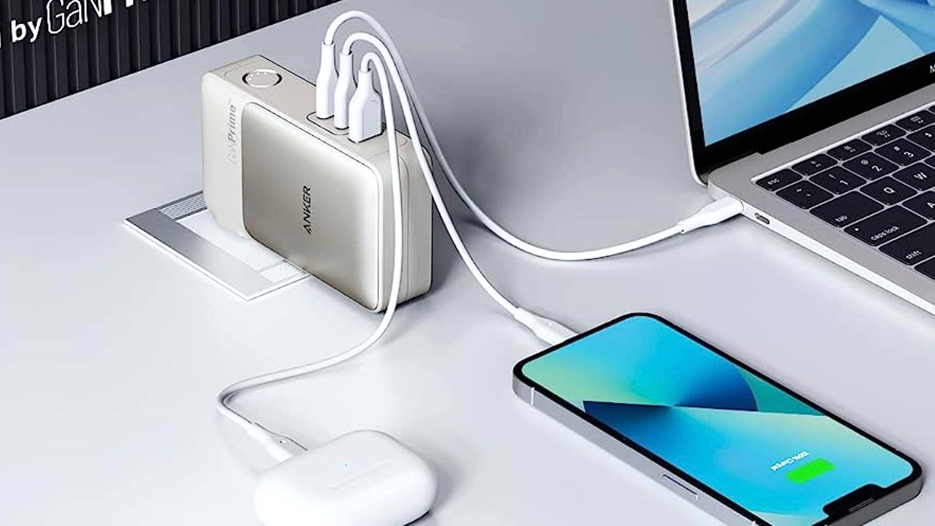 Banque d'alimentation Anker 733 sur un bureau blanc connecté à un ordinateur portable et à un smartphone