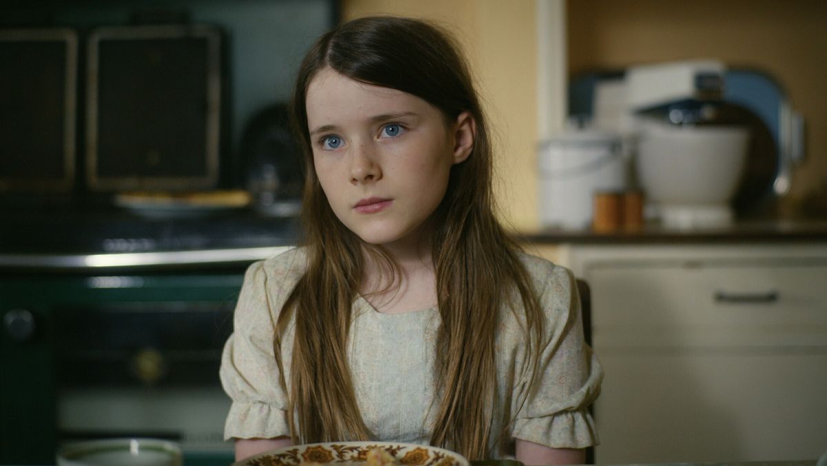 Catherine Clinch dans le rôle de Cáit assise à une table dans The Quiet Girl.