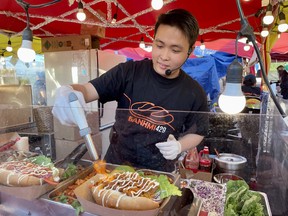 Un sandwich bahn mi en préparation chez Bahnmi429, l'un des nombreux vendeurs du marché nocturne de Richmond.  (EDDIE CHAU/Toronto Sun)