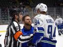 Roman Kaszczij (au centre) s'occupe de l'attaquant des Canucks d'Abbotsford Linus Karlsson lors d'un match la saison dernière.  Kasczij a été promu par les Canucks de Vancouver au poste de thérapeute sportif en chef.