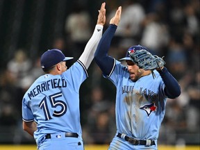 Whit Merrifield, à gauche, et George Springer des Blue Jays de Toronto célèbrent après avoir battu les White Sox de Chicago 5-4 dans le deuxième match