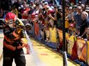 Une foule regarde Marc-André Gosselin du service d'incendie de Montréal terminer l'une des six étapes lors des matchs et de la journée de pique-nique des Championnats canadiens Firefit à Montréal, le samedi 2 juillet 2022.