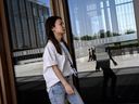 Une femme passe devant le portail du siège de la Banque asiatique d'investissement dans les infrastructures (AIIB) à Pékin le 15 juin 2023. 