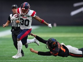 Le numéro 30 des Alouettes fuit un joueur plongeant des Lions de la Colombie-Britannique sous les yeux d'un arbitre