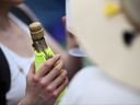 Un fan de tennis boit du champagne le sixième jour des championnats de Wimbledon 2023 au All England Club de Wimbledon, en Angleterre, le samedi 8 juillet 2023.