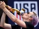 La joueuse de football américaine Megan Rapinoe embrasse le trophée de la coupe du monde féminine.