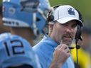 L'entraîneur-chef des Argonauts de Toronto, Ryan Dinwiddie, s'entretient avec le quart-arrière Chad Kelly (12) lors de la première mi-temps de l'action pré-saison de la LCF contre les Redblacks d'Ottawa à Guelph, en Ontario.  le jeudi 1er juin 2023. Les Argonauts ont signé mardi Dinwiddie pour une prolongation de plusieurs années.