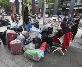 Les réfugiés demandeurs d'asile qui sont venus au Canada en provenance de pays africains comme l'Ouganda, le Kenya, le Nigéria et la Tanzanie campent à l'extérieur de l'établissement pour sans-abri de la rue Peter, le jeudi 13 juillet 2023.