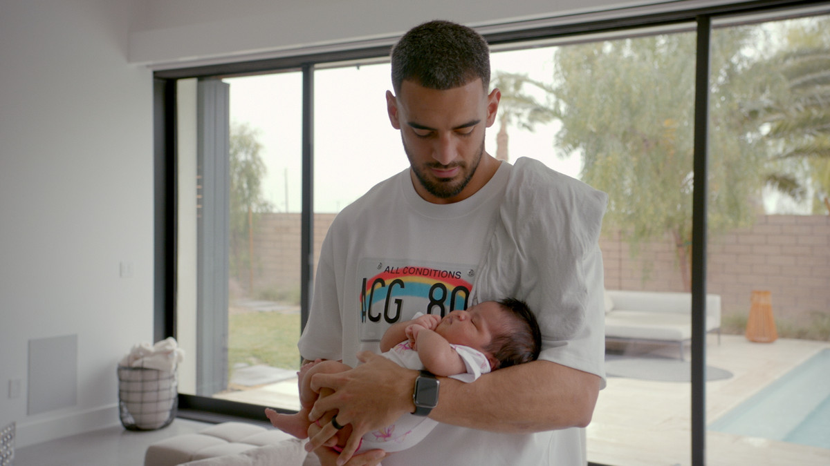 Marcus Mariota tenant son enfant dans ses bras dans Quarterback de Netlfix