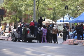 Une camionnette grise roulée devant un refuge de la ville de Toronto sur la rue Peter – où des réfugiés venus au Canada de pays comme l'Ouganda, le Kenya et le Nigeria dorment dans la rue en attendant un logement – ​​le vendredi 14 juillet , 2023.