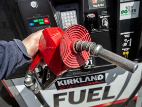 Une personne pompe de l'essence dans une station-service