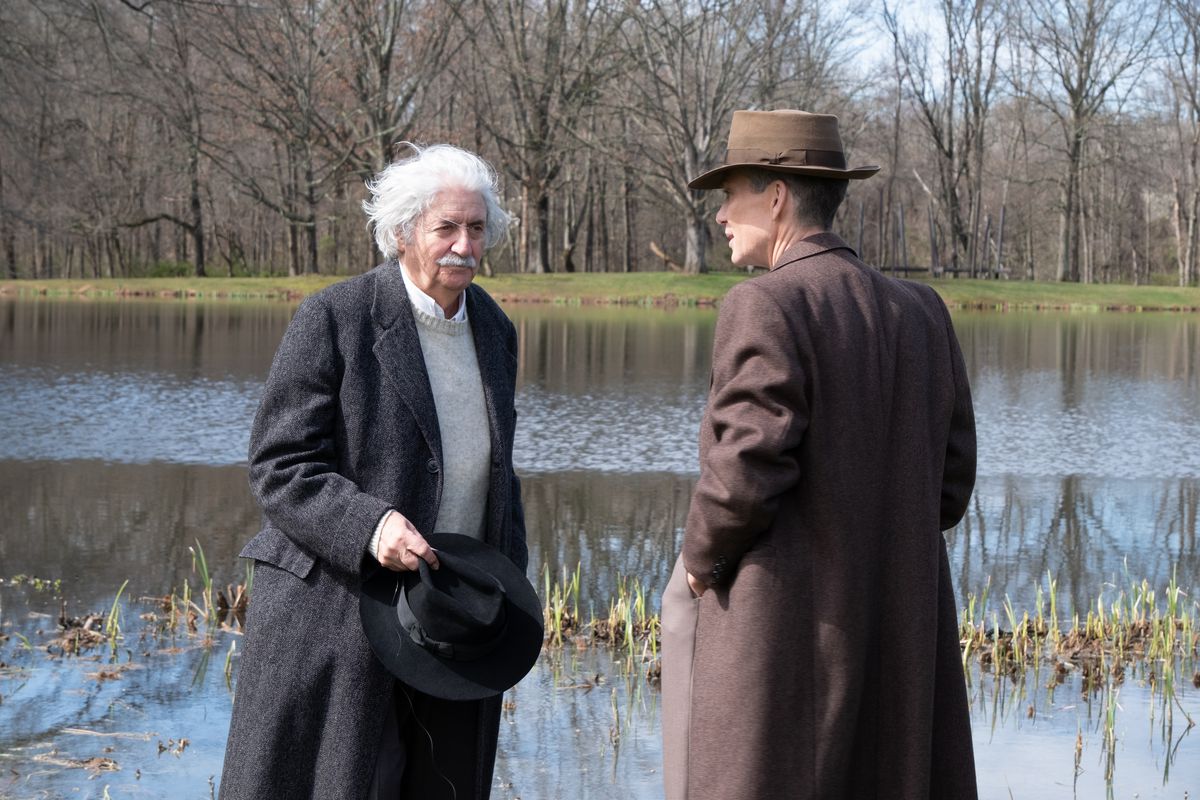 Tom Conti dans le rôle d'Albert Einstein et Cillian Murphy dans le rôle de J.Robert Oppenheimer discutent au bord d'un lac dans le film Oppenheimer