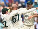 Nathan Lyon (C) en Australie célèbre avec ses coéquipiers Travis Head (L) et Pat Cummins après le licenciement de Mohammed Siraj en Inde.