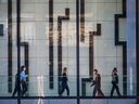 Des employés de bureau traversent Brookfield Place au centre-ville de Calgary.