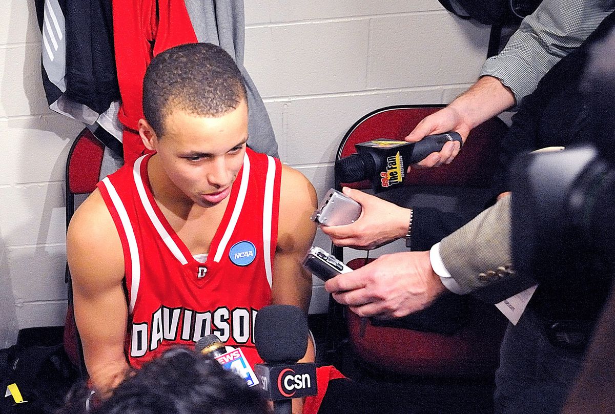 Stephen Curry assis sur une chaise, parlant dans plusieurs microphones dans Stephen Curry : Underrated.