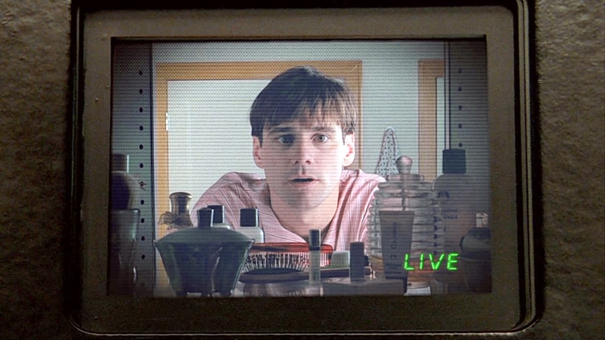 Truman (Jim Carrey) regardant la caméra dans le miroir de sa salle de bain dans Truman Show