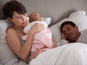 Mère câlins bébé nouveau-né au lit à la maison