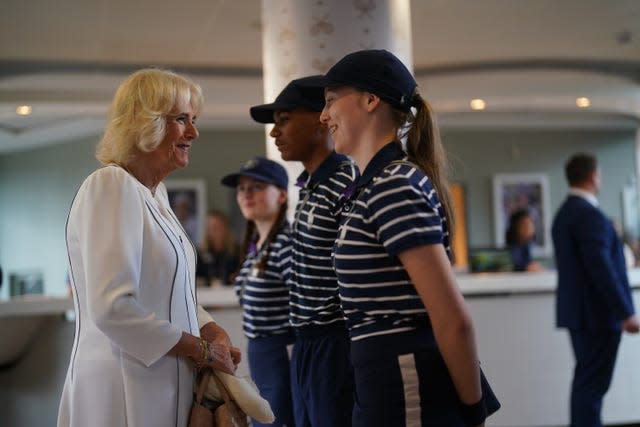 La reine Camilla rencontre le garçon de balle et les filles de balle, Larissa, Sean et Cassie, alors qu'elle arrive pour sa visite le jour 10 des championnats de Wimbledon 2023 au All England Lawn Tennis and Croquet Club à Wimbledon