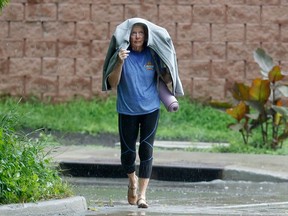 OTTAWA - 13 juillet 2023 - Une femme traverse une tempête de pluie à Ottawa jeudi.  La ville d'Ottawa était sous surveillance de tornade à l'époque.