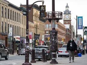 Un homme marche sur le trottoir à Peterborough, en Ontario, le 17 avril 2020.