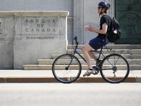 Un cycliste passe devant la Banque du Canada à Ottawa.