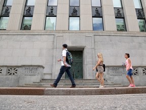 Des piétons passent devant l'édifice de la Banque du Canada à Ottawa.